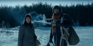 Joyce (Winona Ryder) and Murray (Brett Gelman) look nervous - in the snow. Maybe something to do with the plane that crashed behind them?